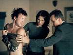 Reyes y Doggett observan la espalda de Winky, donde est� escrito el nombre del programa de cable del chico