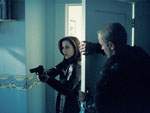 Scully ingresa al cuarto de William con su arma en alto... sin notar que Comer la espera detr�s de la puerta