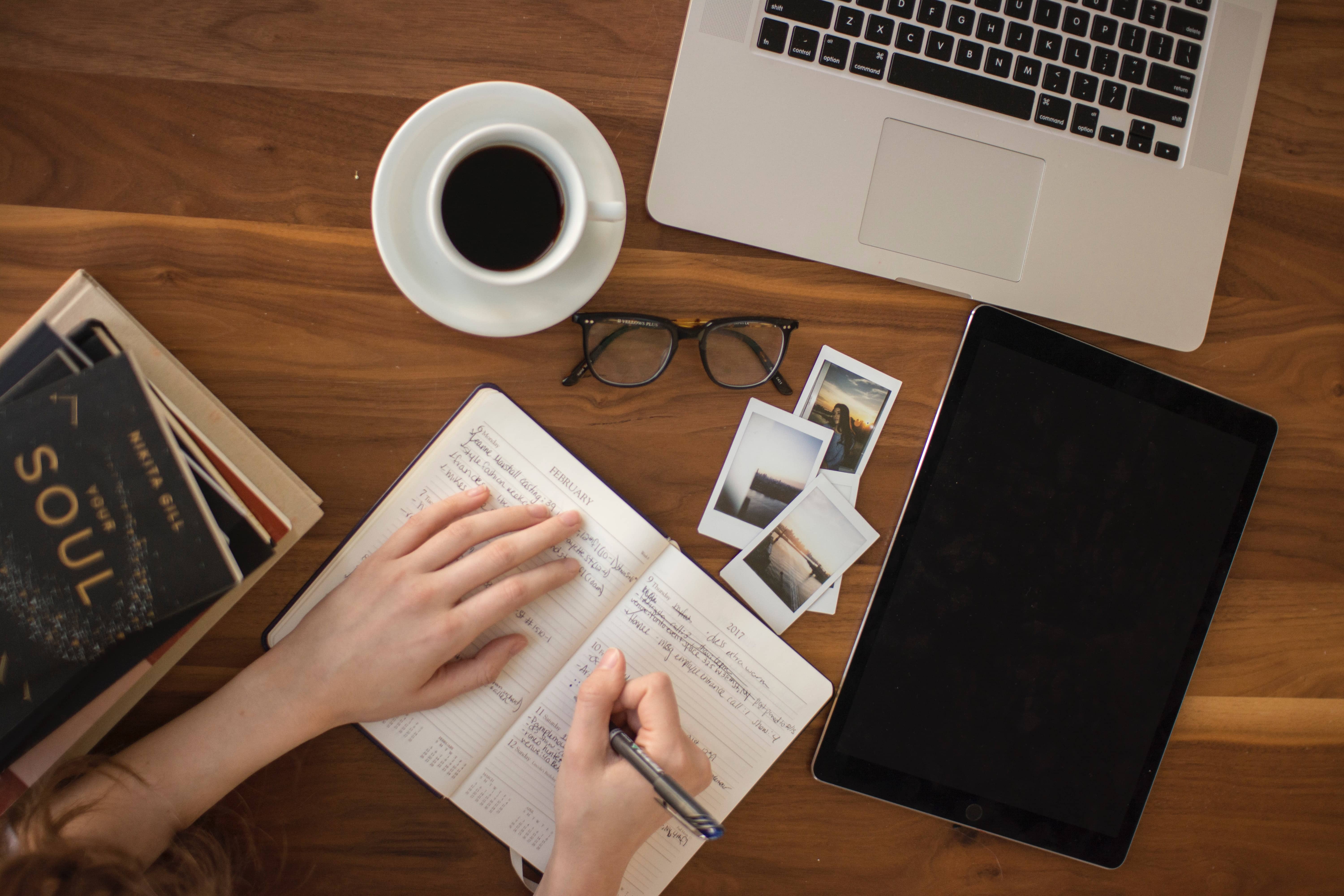 notebook with pen, laptop, and coffee