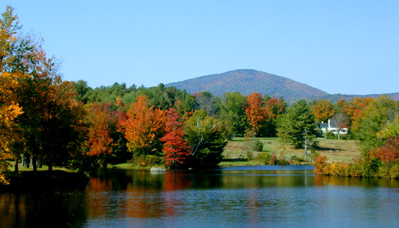 A lake in New Hampshire in the fall, looking accross the lake with a mountian in the background
