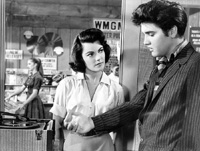 Vince (Elvis) and Peggy) Judy Tyler are surprised  to hear a new version of their song in Jailhouse Rock