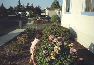 Olivia smelling flowers at her home in OR.